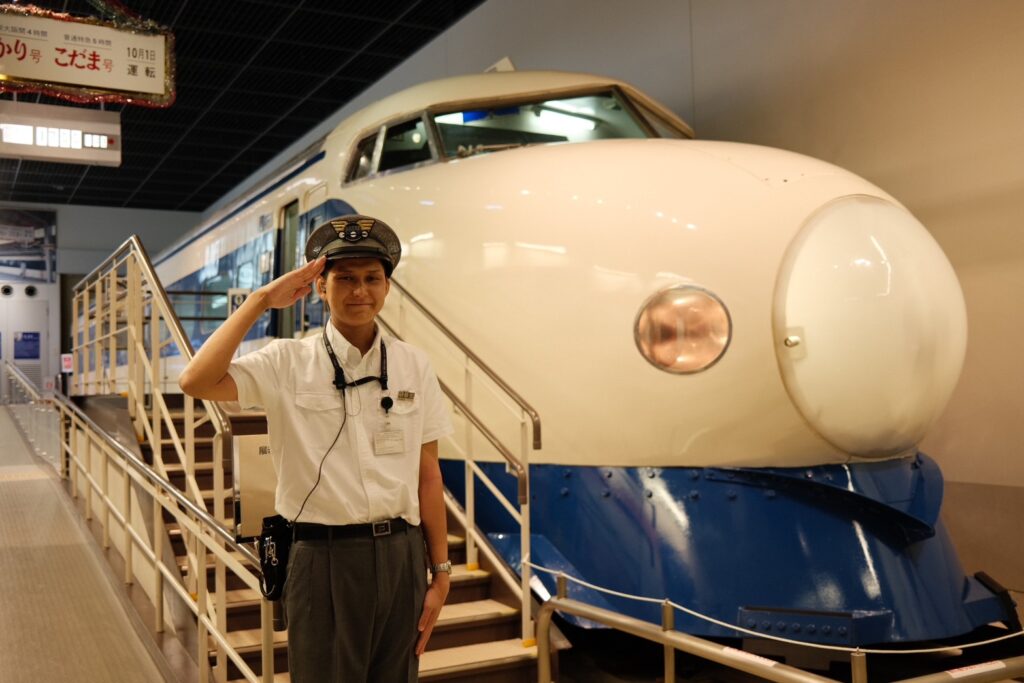 A staff posing in front of an actual Series 0 Shinkansen