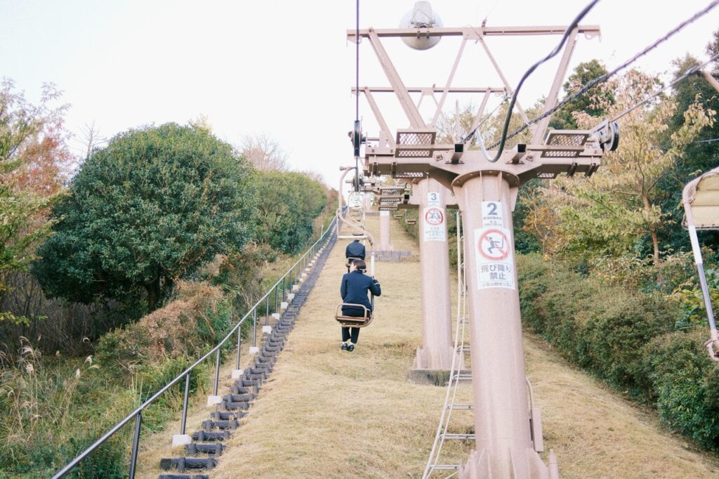 Girl riding Mount Komuro chair lift