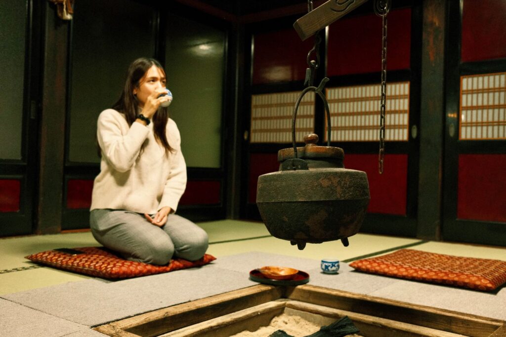 Sitting in front of the irori, a traditional Japanese sunken hearth.
